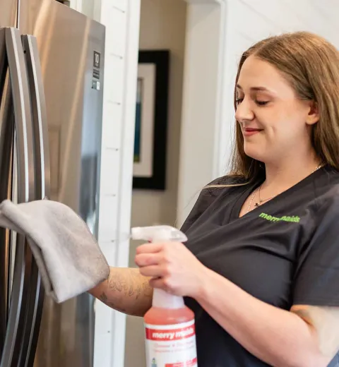 Merry Maids team member cleaning kitchen appliances