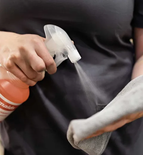 Spraying cleaner on a cloth