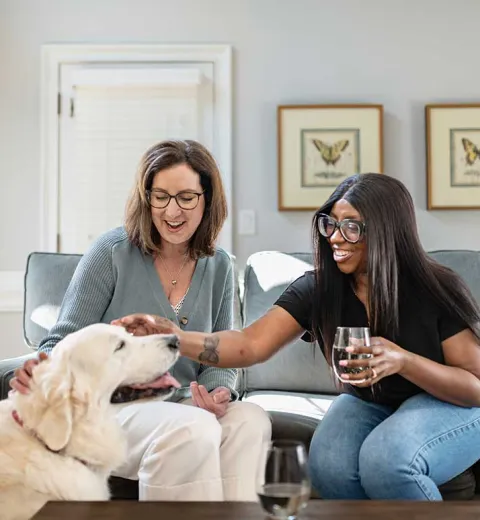 Two ladies on couch with dog