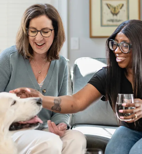 Two Friends drinking Wine and Petting Dog