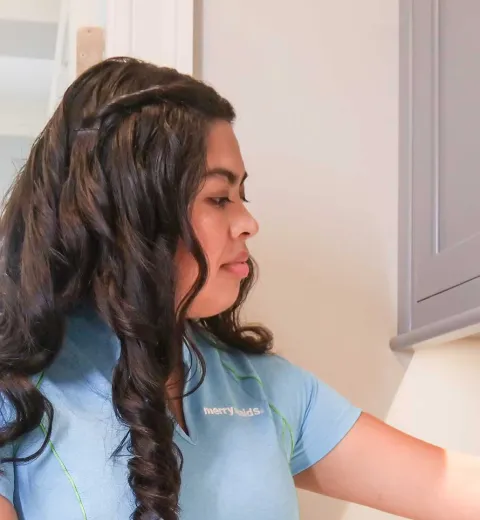 Merry Maids cleaner wiping faucet