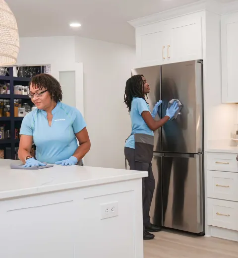 Two Merry Maids team members cleaning kitchen