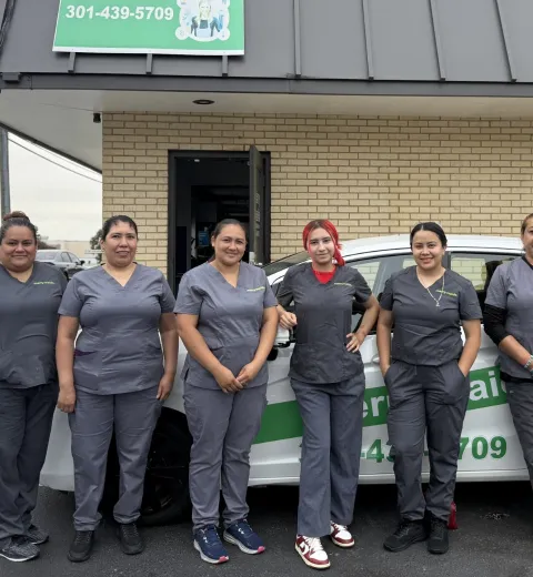 group of smiling merry maids wearing grey uniforms