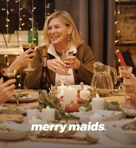 family smiling around holiday dinner table