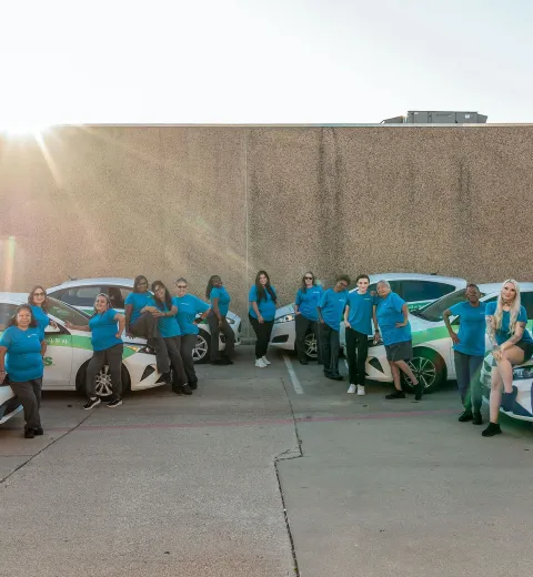 Merry maids standing in front of branded vehicles