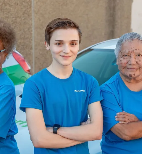 merry maids posing by branded vehicles