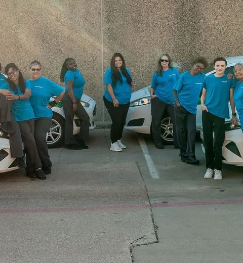 whole merry maids team posing by branded vehicles