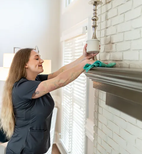 merry maid cleaning a fireplace mantle