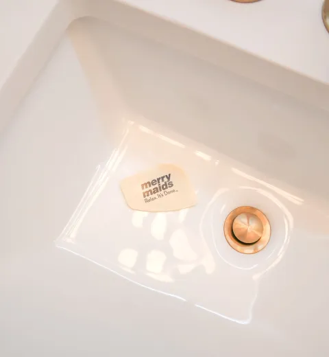 clean bathroom sink with merry maids card