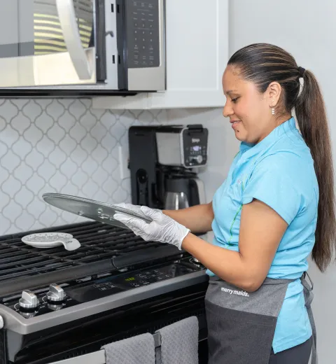 merry maid cleaning the glass microwave tray