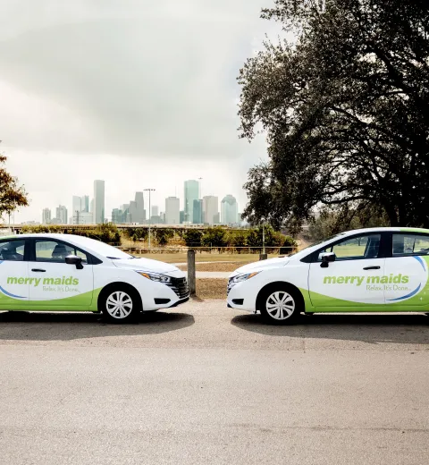 merry maids cars in front of the houston skyline
