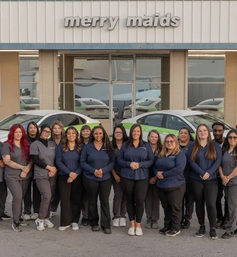 merry maids posing by branded vehicles