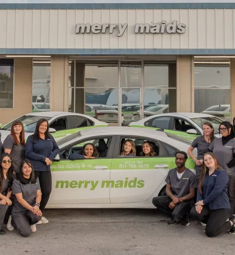 merry maids posing by branded vehicles