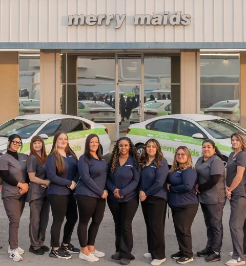 merry maids posing by branded vehicles