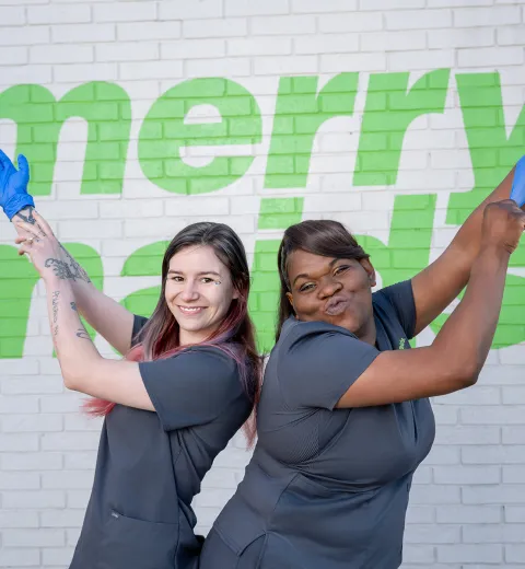 merry maids posing by a white brick wall