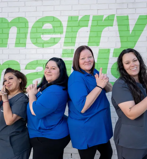 merry maids posing by a white brick wall
