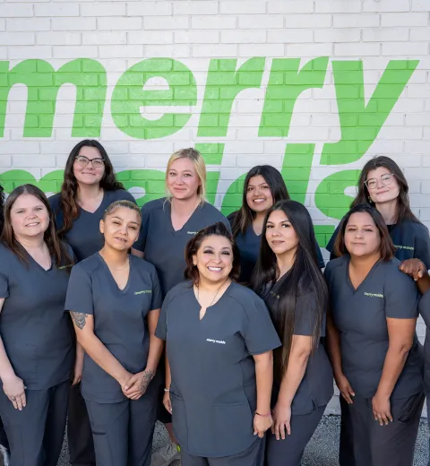 merry maids standing in front of a white brick wall