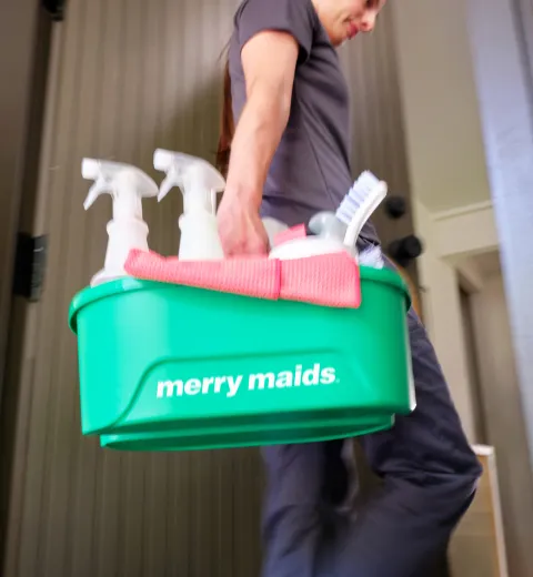 merry maid carrying cleaning supplies