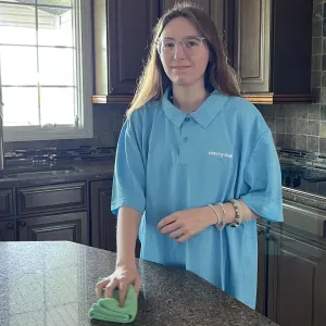 Cleaner wiping counter island in kitchen