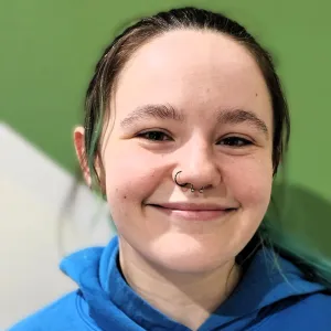 Erika is wearing a blue merry maids tshirt standing in front of a green and white wall