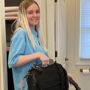 gracie is seen smiling while she is vacuuming