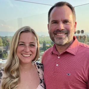 man and woman smiling in front of a sunset