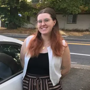 Taylor- Merry Maids employee standing by a car