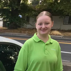 Vira- Team member with Merry Maids, standing next to a car