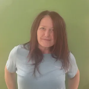 Nadia standing in front of a green wall with her hands on her hips