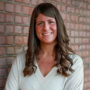 smiling woman in front of a brick wall