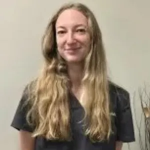 merry maid smiling in front of a tan wall