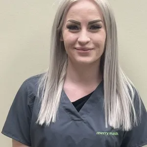 Smiling female in grey scrubs with Merry Maids logo with straight blonde hair