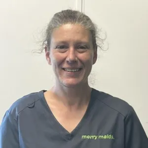 A smiling female Merry Maids ambassador in grey scrubs 