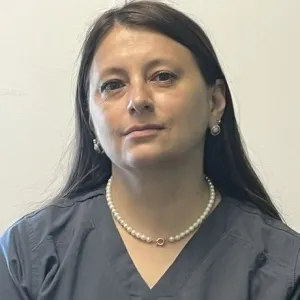 Smiling female in grey scrubs with Merry Maids logo with long hair