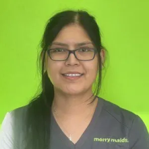 Smiling female in grey scrubs with Merry Maids logo with straight dark hair