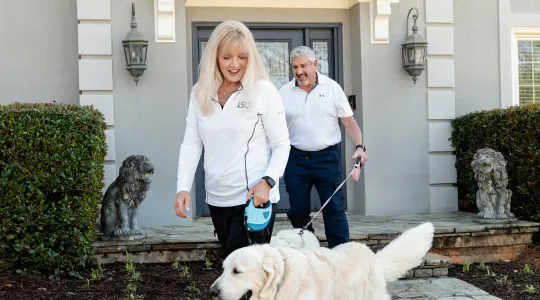 Couple outside home with dog