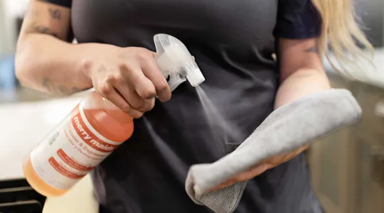 Spraying cleaner on a cloth