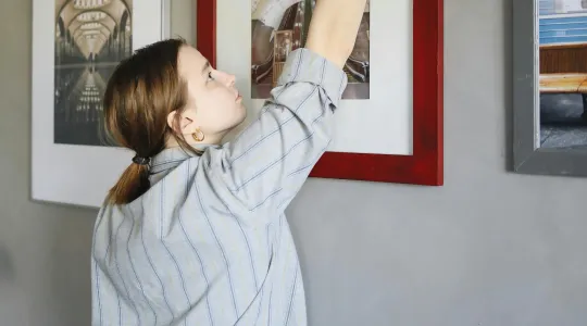 woman dusting a picture frame