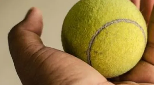 Tennis ball in hand