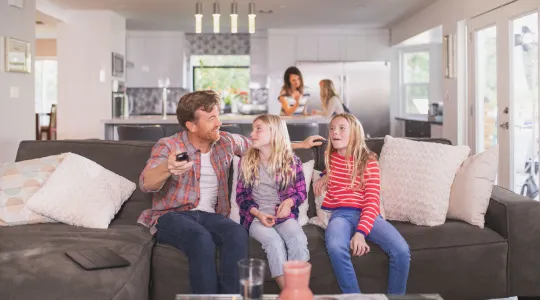 Family gathers on the couch to watch television