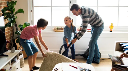 dad daughter and son vacuuming rug