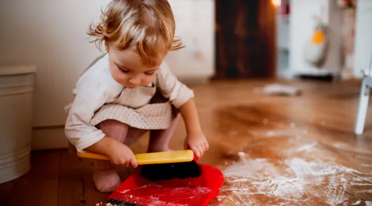 Child Sweeping Up Floor