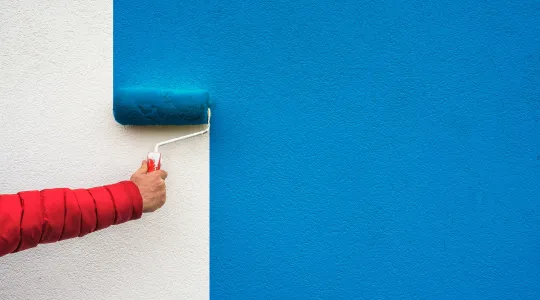 Hand painting a wall blue | Merry Maids