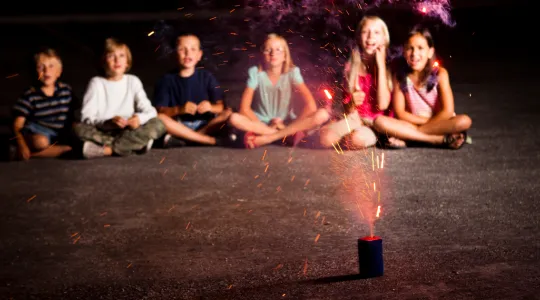 Kids sitting watching a sparkler | Merry Maids