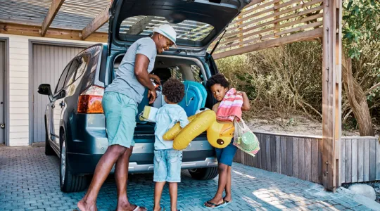 A family packing the car to leave for summer vacation | Merry Maids