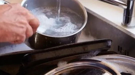 cleaning pots and pans in the sink