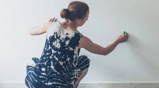 Woman cleaning walls in her home