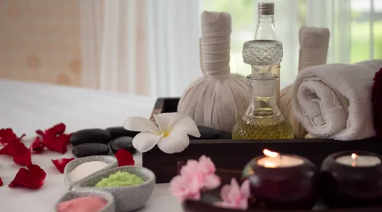 Bath salts and oils sitting nicely on a bed with a tray of towels | Merry Maids