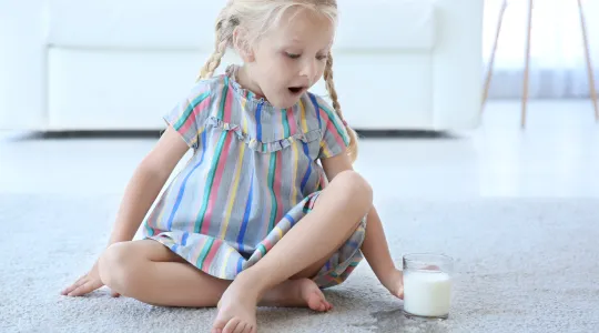 Girl spills milk on carpet