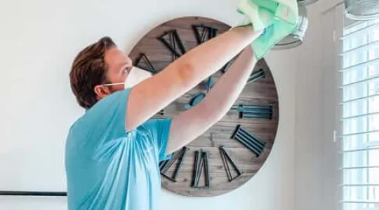 Man cleaning a light fixture | Merry Maids